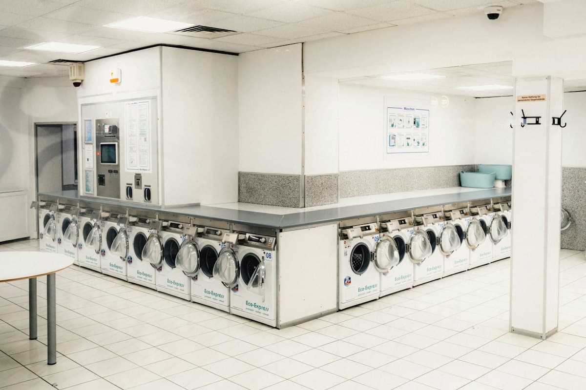 Laundromat with rows of washing machines, served by a pickup and delivery app